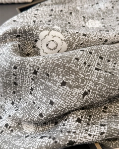 Vue détaillée du motif camélia sur foulard en soie avec texture à chevrons