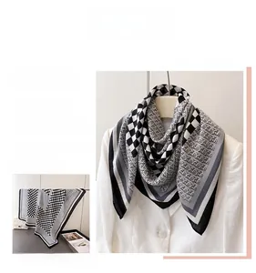 Gros plan d'un foulard en soie à carreaux noir et blanc avec des motifs floraux