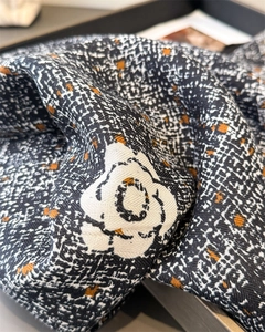 Gros plan macro sur l'imprimé camélia vintage et le tissu soyeux aux détails oranges