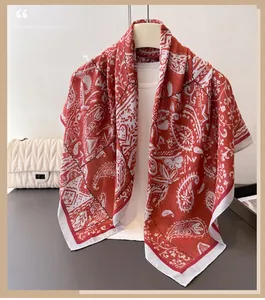 Detailed view of red and white paisley faux silk scarf draped with a chic handbag