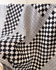 Détail de la texture damier et pointillée sur le tissu en soie avec motif noir et blanc