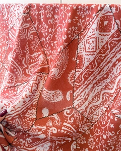 Detail of red and white paisley print fabric scarf with vintage patchwork stitching