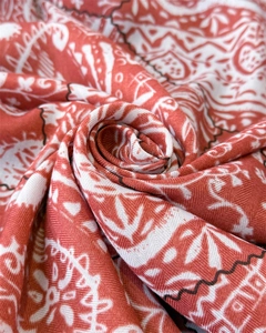 Macro view of vintage paisley silk-feel scarf showing fine twill texture and warm terracotta