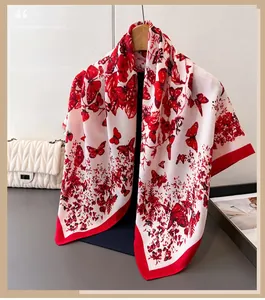 Détail d'un élégant foulard en soie avec papillons rouges et motifs floraux