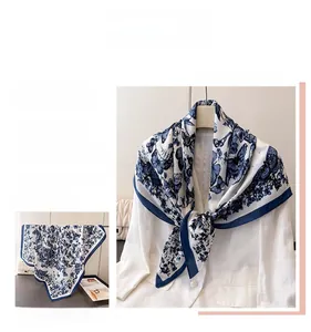 Détail d'un élégant foulard en soie avec imprimé papillon bleu marine sur tissu blanc