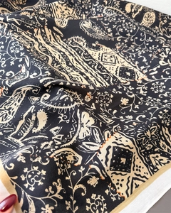 Macro view showing paisley print and twill weave texture on silk-like square scarf