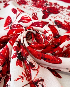 Gros plan d'un foulard en soie avec papillon rouge et imprimés floraux en sergé