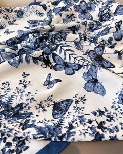Vue détaillée du motif floral et papillon sur un foulard en sergé de soie élégant