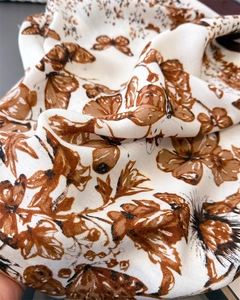 Détail d'un foulard en soie avec imprimé papillon marron et texture sergée élégante