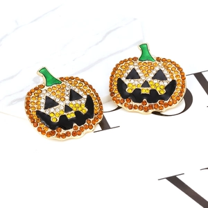 Halloween pumpkin stud earrings with orange rhinestones and green enamel on white background