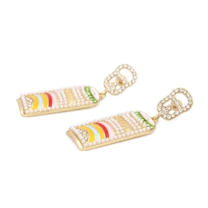 Detailed macro view of beer can earrings with colorful enamel stripes and pearl accents