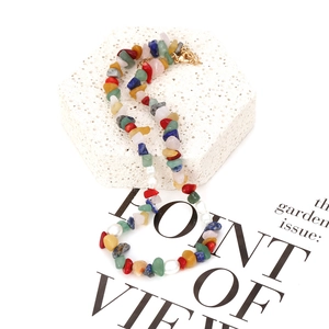 Detail of colorful gravel stones and white pearls necklace with a gold clasp