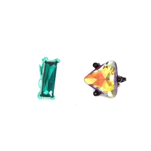Détail de clous d'oreilles géométriques en verre vert émeraude et cristaux irisés sertis griffes