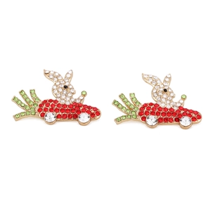 Detail view of crystal-studded rabbit driving a carrot car earrings in gold plating