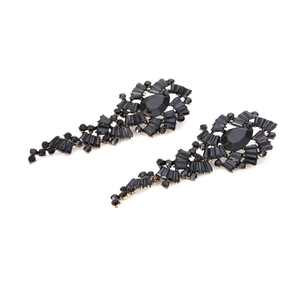 Dettaglio degli orecchini pendenti con strass neri e design vintage di lusso raffinato