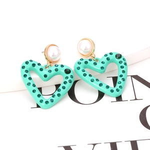 Mint green enamel heart earrings with green rhinestones and pearl stud on white background