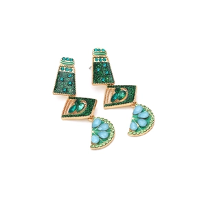 Detailed view of bohemian layered fruit earrings with emerald crystals and gold finish