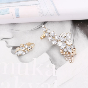Detailed shot of gold flower tassel earrings featuring asymmetric crystal fringe and rhinestones
