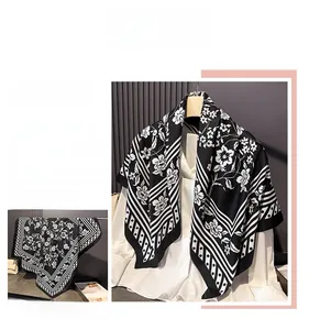 Detail view of large black and white floral silk scarf with elegant geometric patterns