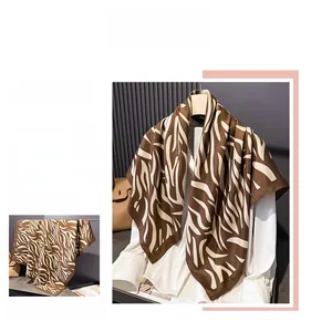 Détail d'un foulard en soie à imprimé zébré café drapé sur une chemise blanche