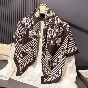 Floral print silk-like satin square scarf in dark brown draped over a white blouse
