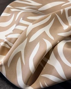 Vue macro du tissu en soie synthétique avec motif de feuilles kaki et satin