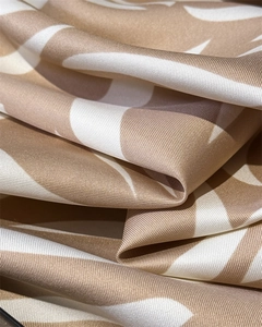 Gros plan du motif abstrait à vagues sur tissu de soie sergé beige et blanc élégant