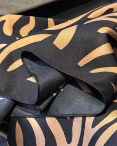 Détail du tissu de foulard en soie montrant le tissage sergé et le motif géométrique noir
