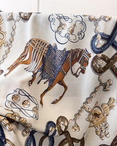 Close-up of silk scarf showing equestrian patterns and twill fabric texture