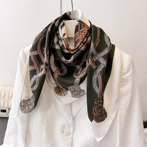 Detail of vintage print silk scarf featuring rope and tassel patterns on a white blazer