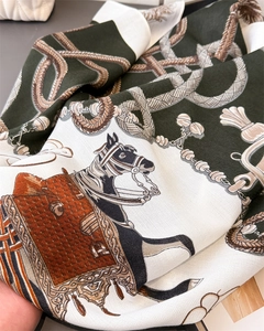 Macro view of silk scarf with equestrian horse prints and herringbone texture weave
