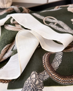Macro detail of twill silk scarf showing classic equestrian rope patterns on green fabric