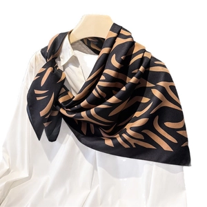 Élégant foulard en soie noir avec motif de feuilles bronze sur chemise blanche