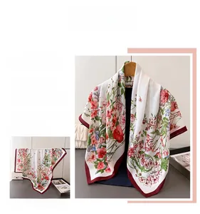 Detail of silk-like scarf featuring elegant red floral print and herringbone patterns