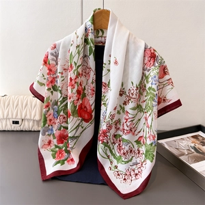 Floral print silk scarf with burgundy edges hanging on wooden hanger for women
