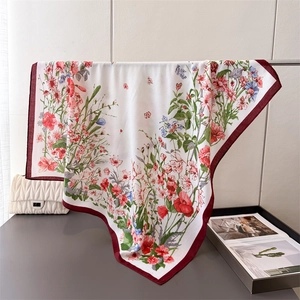Elegant floral silk satin square scarf with burgundy border draped on a metal bar