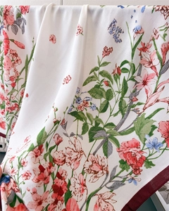 Close-up of lightweight floral silk scarf with pink flower prints and red border edge