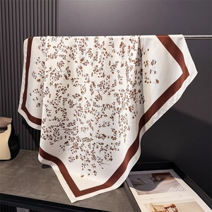 Detailed close-up showing the silky floral print texture of the elegant square scarf