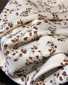 Macro shot of silk satin scarf showing smooth texture and leopard print patterns
