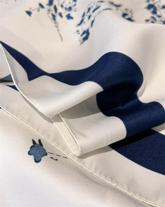 Detailed view of floral silk-feel scarf with blue stripes and fine twill texture