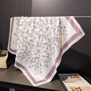 Detail of floral silk scarf hanging to show smooth texture and elegant purple border