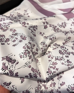 Close-up of floral twill silk scarf showing elegant purple flower patterns and texture