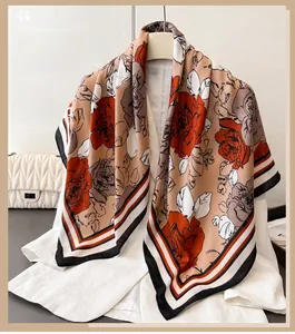 Detail of rose print silk scarf on a hanger with elegant khaki floral and geometric border