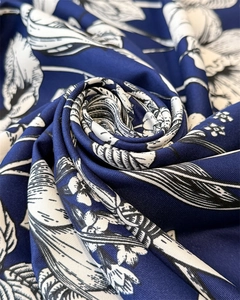 Detail of silk-like scarf with white floral print on dark blue fabric texture