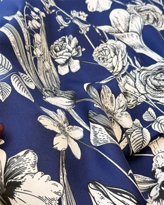 Macro shot of navy blue twill fabric showing white floral print and silky texture