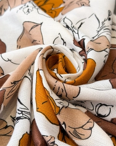 Detailed close-up showing the elegant rose print and fine twill silk texture of the scarf