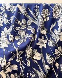 Detailed close-up of dark blue silk scarf featuring elegant white floral iris print patterns