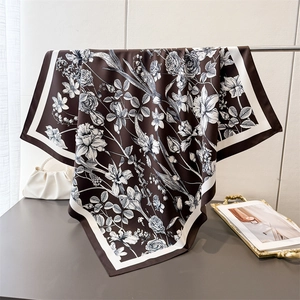 Detail of elegant silk square scarf with vintage floral patterns and smooth texture