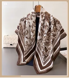 Detail of silk satin scarf with brown botanical prints hanging on a wooden hanger