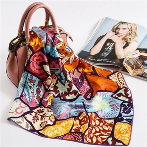 Silk satin square scarf with colorful patchwork floral patterns tied on a handbag